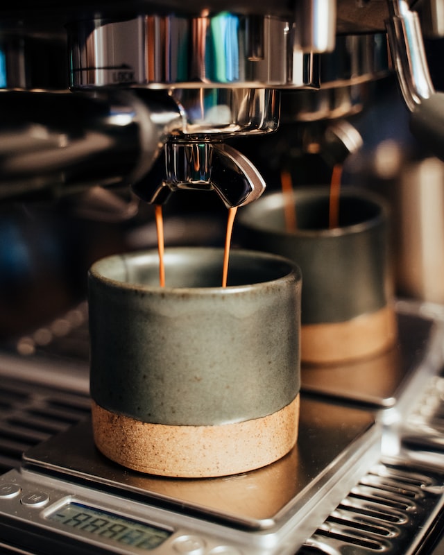 Espresso brewing into a stoneware cup.