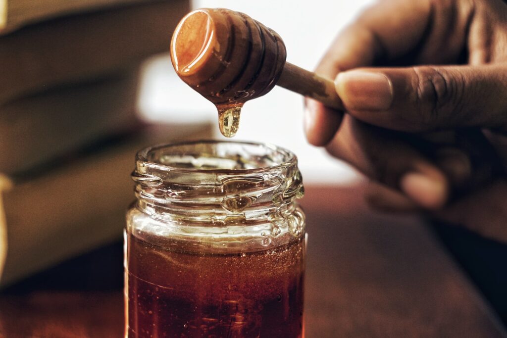 A honey dipper in a jar