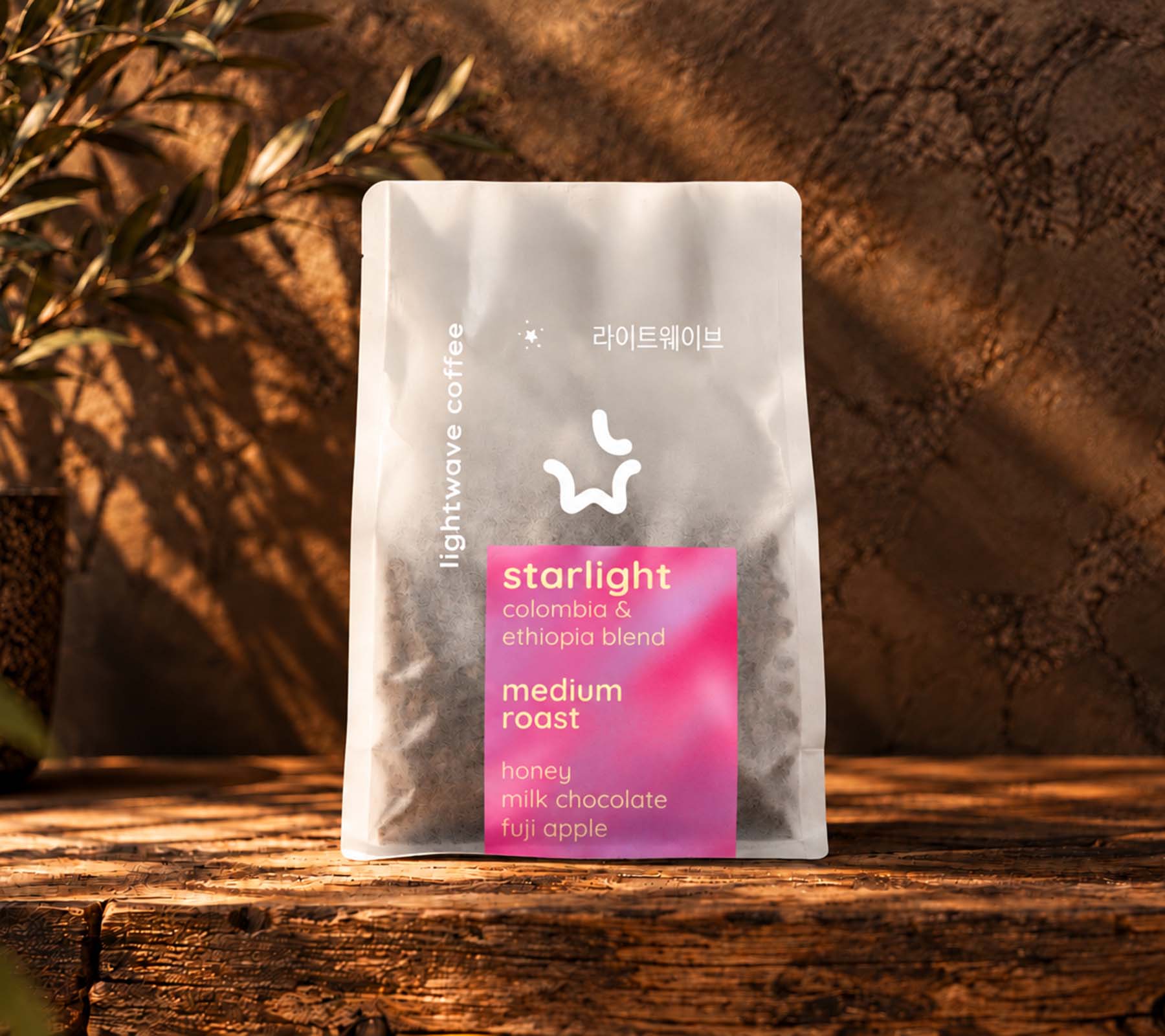 Lightwave Coffee Starlight medium roast blend whole bean coffee bag on a rustic wooden counter in warm sunlight